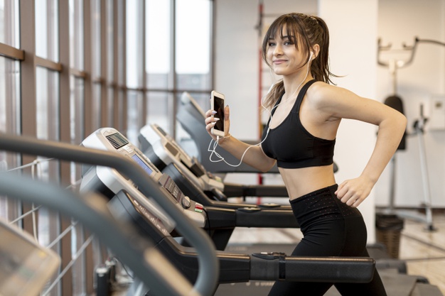 woman with mobile running treadmill - Đâu là địa hình chạy lý tưởng và Tại sao cần thay đổi địa hình chạy